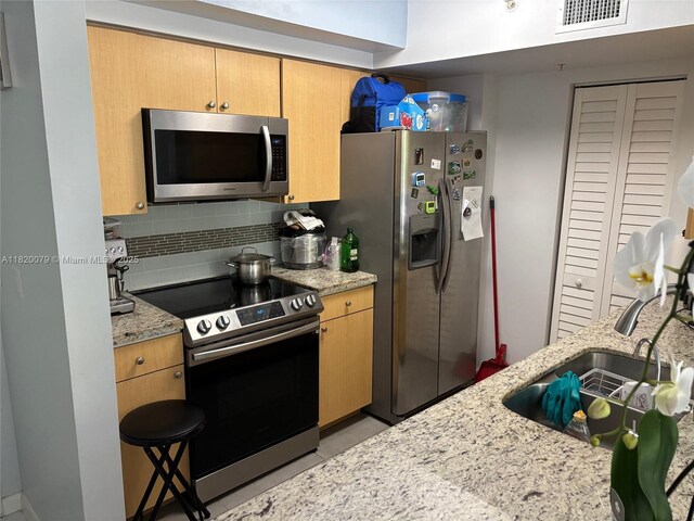 1900 Van Buren St Unit 209B, Hollywood, FL 33020 - kitchen with stainless steel appliances, backsplash, and light stone counters