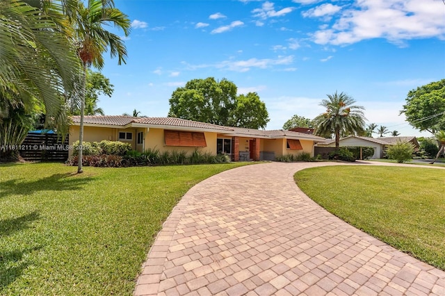 901 W Tropical Way, Plantation, FL 33317 - ranch-style house featuring curved driveway, stucco siding, and a front lawn