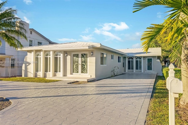 3421 SW 4th St, Miami, FL 33135 - rear view of house featuring french doors, stucco siding, a tile roof, and decorative driveway