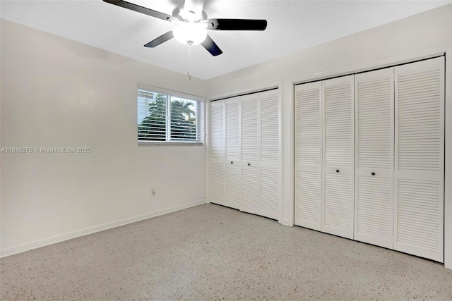 3421 SW 4th St, Miami, FL 33135 - unfurnished bedroom with two closets, dark speckled floor, and a ceiling fan