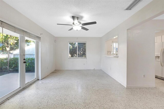 3421 SW 4th St, Miami, FL 33135 - empty room featuring speckle patterned floor, a ceiling fan, healthy amount of natural light, and a textured ceiling