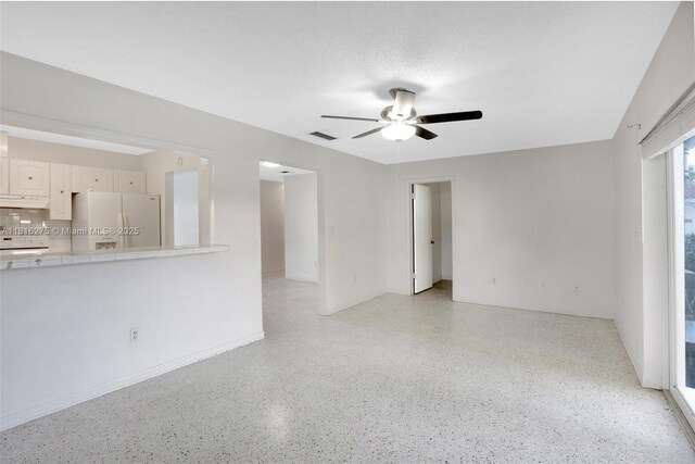 3421 SW 4th St, Miami, FL 33135 - unfurnished living room with dark speckled floor and a ceiling fan