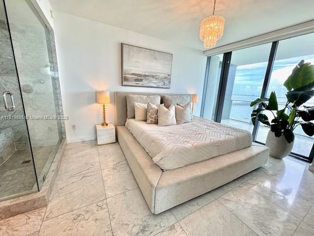 3131 NE 7th Ave Unit 1901, Miami, FL 33137 - bedroom with marble look tiles, a chandelier, access to exterior, and a wall of windows