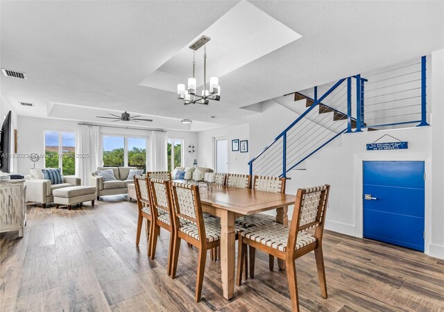 94825 Overseas Hwy, Key Largo, FL 33037 - dining area featuring a raised ceiling, wood finished floors, ceiling fan, stairs, and a chandelier