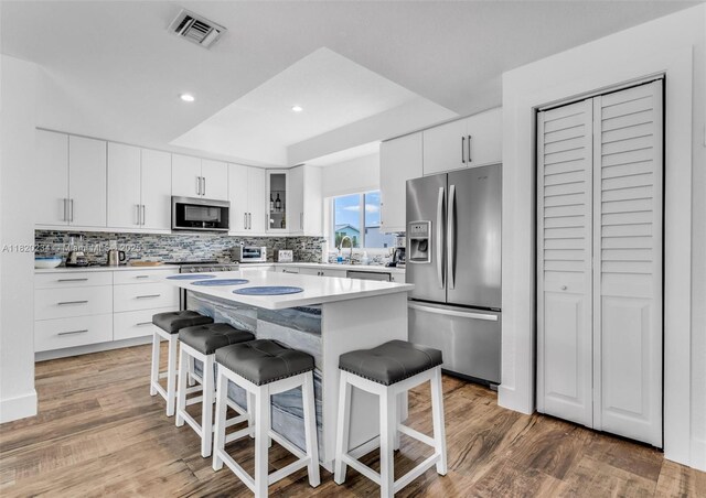 94825 Overseas Hwy, Key Largo, FL 33037 - kitchen with stainless steel appliances, a breakfast bar area, tasteful backsplash, a kitchen island, and recessed lighting
