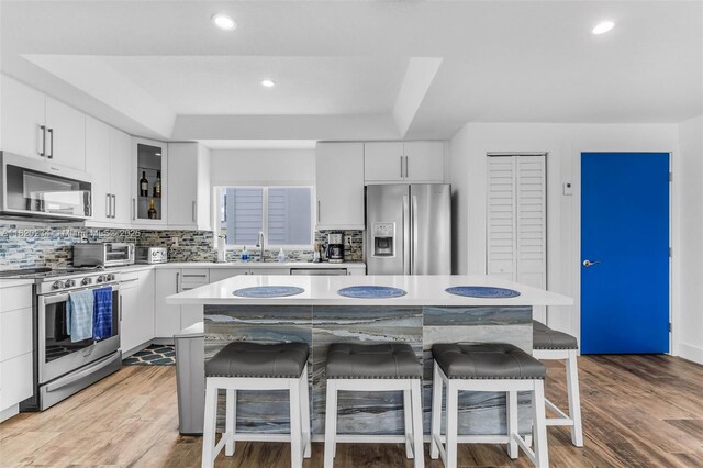 94825 Overseas Hwy, Key Largo, FL 33037 - kitchen with appliances with stainless steel finishes, a breakfast bar, backsplash, light countertops, and recessed lighting