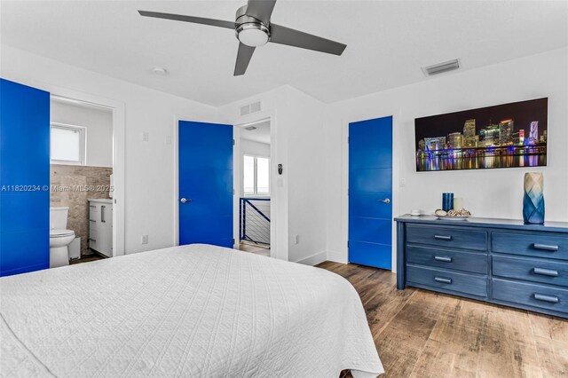 94825 Overseas Hwy, Key Largo, FL 33037 - bedroom featuring wood finished floors, multiple windows, ensuite bathroom, and a ceiling fan