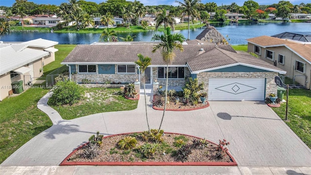 11520 NW 23rd St, Pembroke Pines, FL 33026 - view of front of house with a water view, driveway, stone siding, an attached garage, and a residential view