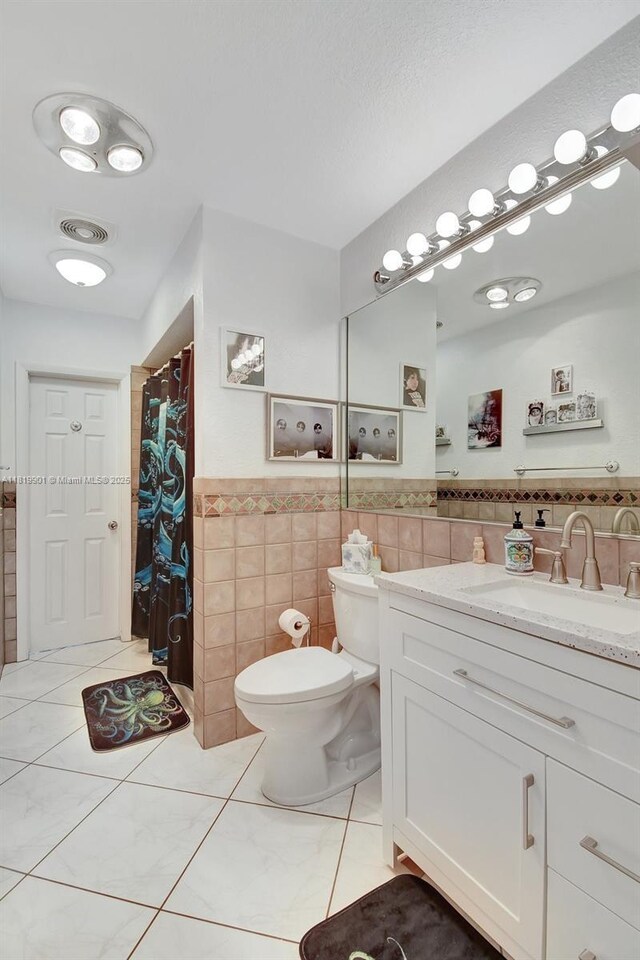 11520 NW 23rd St, Pembroke Pines, FL 33026 - bathroom featuring tile walls, vanity, tile patterned floors, wainscoting, and curtained shower