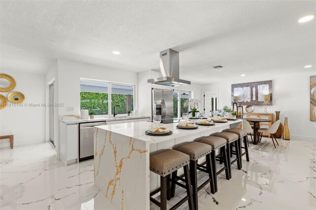 1365 SW 14th St, Boca Raton, FL 33486 - kitchen with appliances with stainless steel finishes, island range hood, white cabinets, light marble finish floors, and recessed lighting