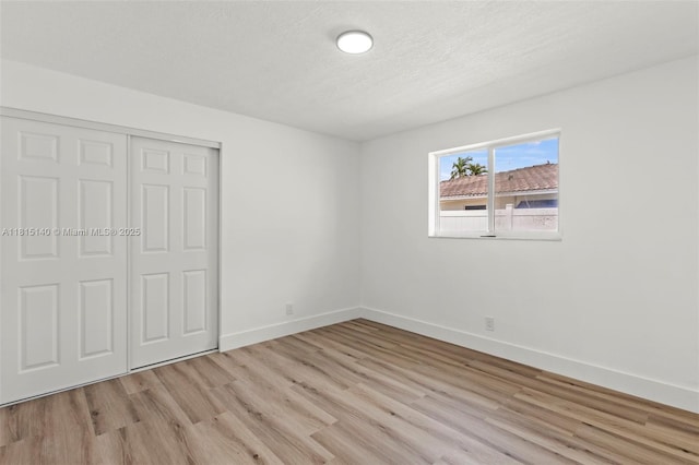 1365 SW 14th St, Boca Raton, FL 33486 - unfurnished bedroom featuring light wood-style flooring, a closet, and a textured ceiling