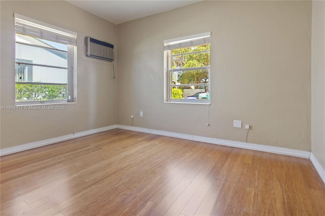 3685 SW 26th St, Miami, FL 33133 - spare room with an AC wall unit, light wood-style floors, and healthy amount of natural light