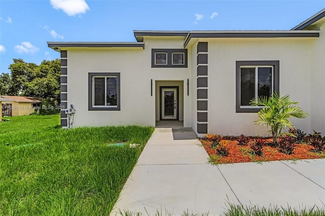 3512 2nd St W, Lehigh Acres, FL 33971 - view of front of property with stucco siding and a front yard