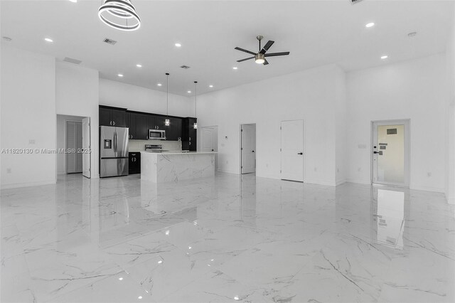 3512 2nd St W, Lehigh Acres, FL 33971 - unfurnished living room with a high ceiling, a ceiling fan, recessed lighting, and light marble finish flooring