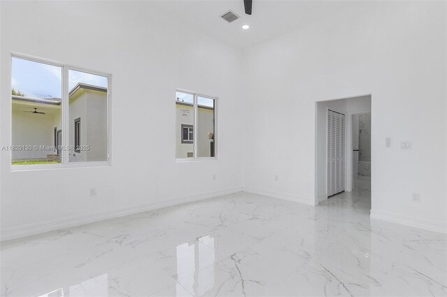 3512 2nd St W, Lehigh Acres, FL 33971 - unfurnished room featuring a ceiling fan, a towering ceiling, and marble finish floors