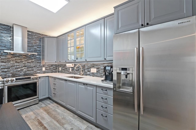 10185 Collins Ave Unit 1508, Bal Harbour, FL 33154 - kitchen with appliances with stainless steel finishes, gray cabinetry, wall chimney range hood, and decorative backsplash