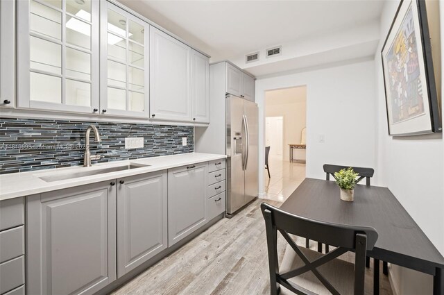 10185 Collins Ave Unit 1508, Bal Harbour, FL 33154 - kitchen with stainless steel refrigerator with ice dispenser, light wood-style floors, light countertops, and tasteful backsplash