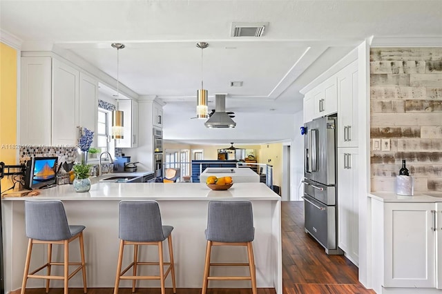 16530 Royal Poinciana Ct, Weston, FL 33326 - kitchen featuring stainless steel appliances, a peninsula, dark wood finished floors, white cabinets, and a kitchen bar