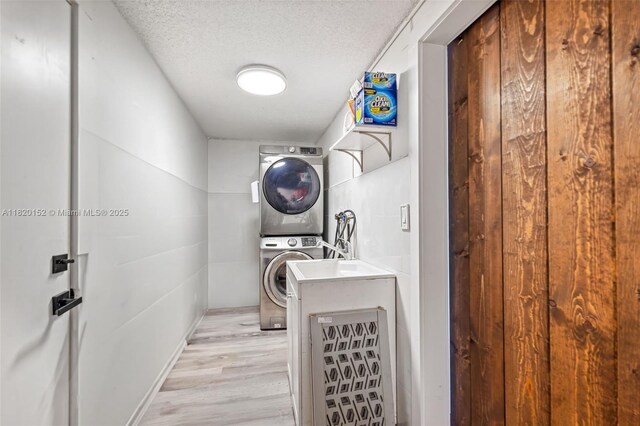 16530 Royal Poinciana Ct, Weston, FL 33326 - washroom with stacked washer / dryer, a textured ceiling, and light wood finished floors