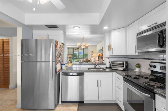 7608 NW 18th St Unit 405, Margate, FL 33063 - kitchen featuring stainless steel appliances, white cabinetry, dark stone countertops, ceiling fan, and a chandelier