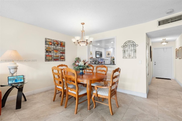 7608 NW 18th St Unit 405, Margate, FL 33063 - dining space featuring a chandelier, light tile patterned floors, and a textured ceiling