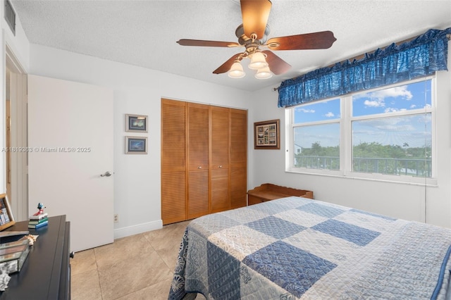 7608 NW 18th St Unit 405, Margate, FL 33063 - bedroom with a textured ceiling, a closet, light tile patterned floors, and ceiling fan