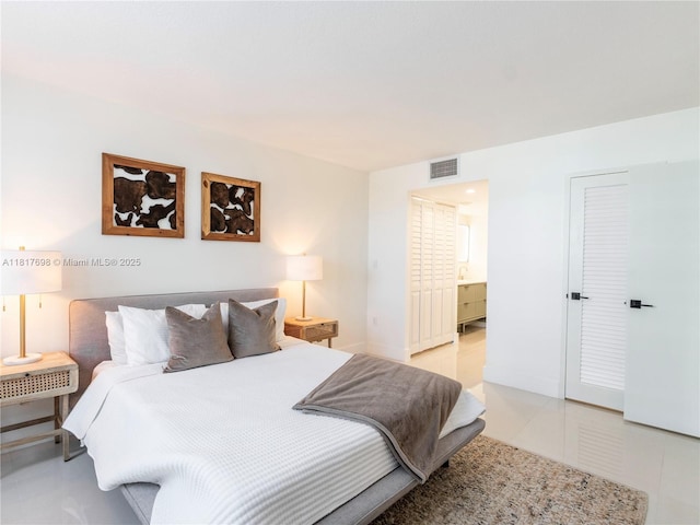 5701 Collins Ave Unit 307, Miami Beach, FL 33140 - bedroom with light tile patterned floors and ensuite bath