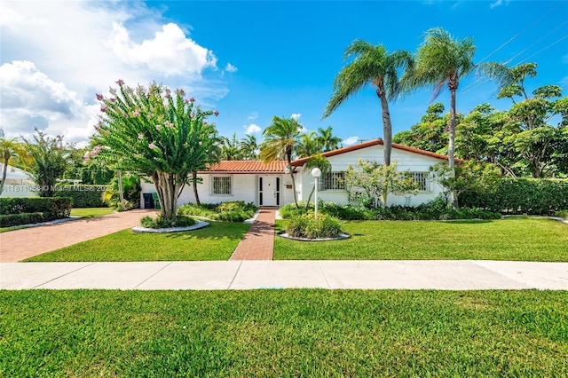 8701 SW 80th St, Miami, FL 33173 - mediterranean / spanish-style house featuring a front yard, a tiled roof, stucco siding, and decorative driveway
