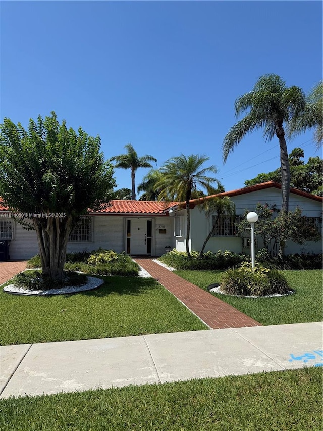 8701 SW 80th St, Miami, FL 33173 - view of front of property with a tile roof and a front yard