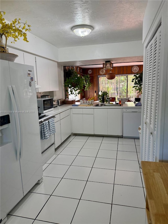 8701 SW 80th St, Miami, FL 33173 - kitchen with white appliances, white cabinetry, a textured ceiling, light countertops, and light tile patterned floors