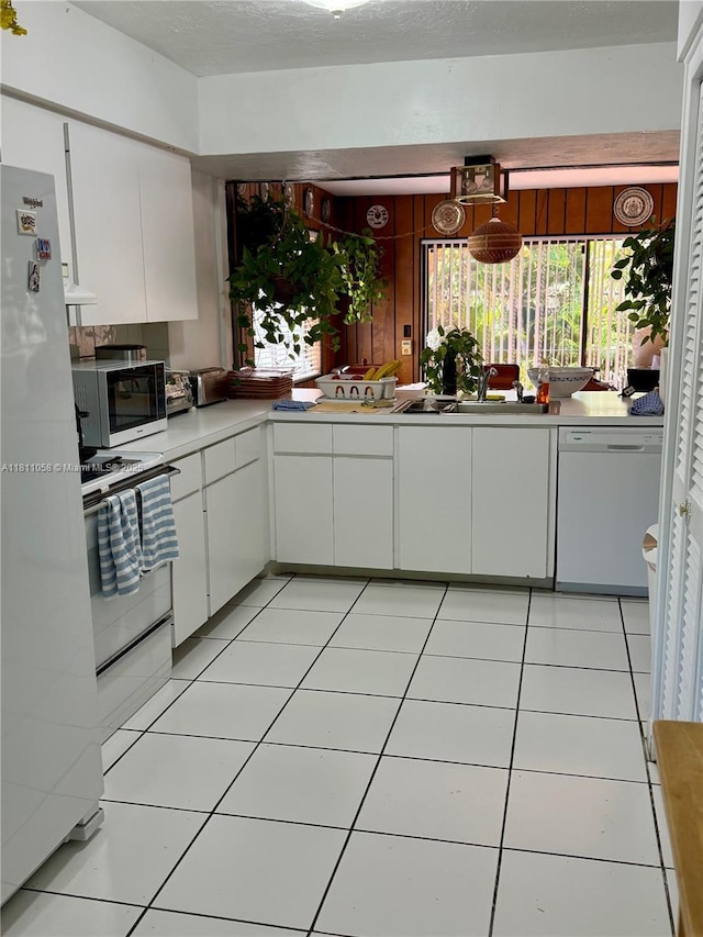 8701 SW 80th St, Miami, FL 33173 - kitchen featuring white appliances, white cabinets, light countertops, ventilation hood, and light tile patterned floors
