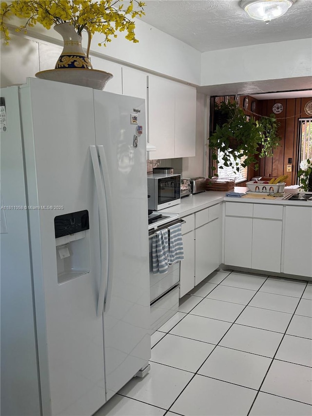 8701 SW 80th St, Miami, FL 33173 - kitchen featuring white appliances, white cabinets, a textured ceiling, light countertops, and light tile patterned floors