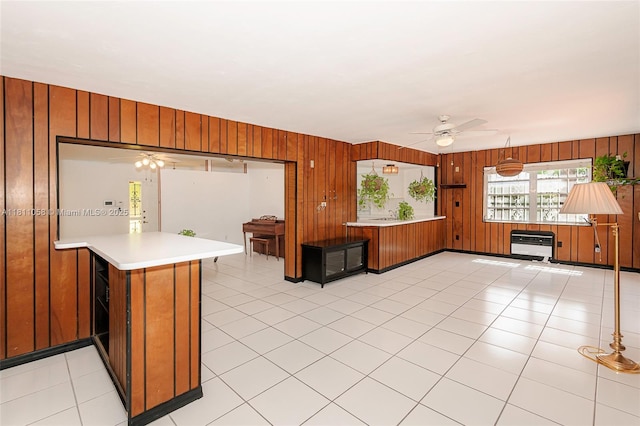 8701 SW 80th St, Miami, FL 33173 - kitchen with a peninsula, ceiling fan, wooden walls, light countertops, and brown cabinets
