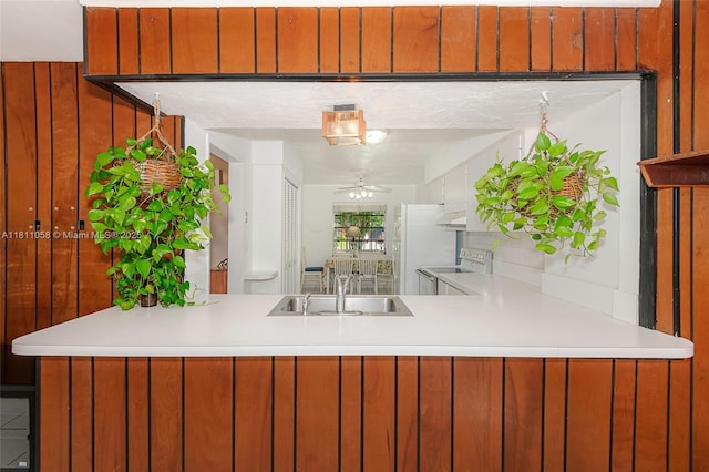 8701 SW 80th St, Miami, FL 33173 - kitchen featuring white appliances, ceiling fan, light countertops, a peninsula, and wooden walls