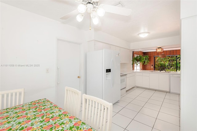 8701 SW 80th St, Miami, FL 33173 - kitchen with white appliances, light countertops, light tile patterned floors, ceiling fan, and white cabinetry