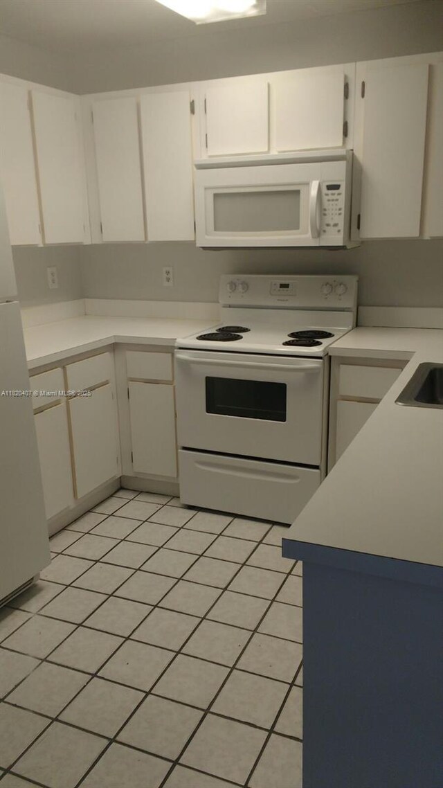 9810 Hammocks Blvd Unit 202, Miami, FL 33196 - kitchen with white appliances, white cabinets, light countertops, and light tile patterned floors