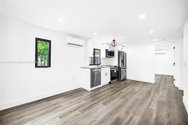 1805 SW 4th St, Miami, FL 33135 - kitchen featuring stainless steel appliances, a wall unit AC, white cabinetry, wood finished floors, and recessed lighting