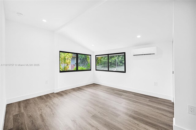 1805 SW 4th St, Miami, FL 33135 - empty room featuring a wall unit AC, wood finished floors, vaulted ceiling, and recessed lighting