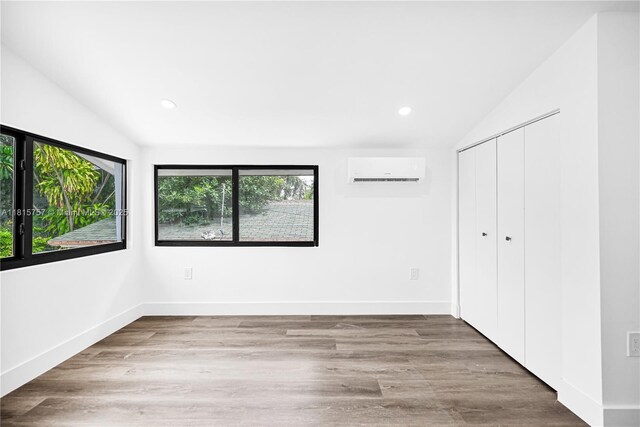 1805 SW 4th St, Miami, FL 33135 - unfurnished bedroom featuring vaulted ceiling, a wall mounted AC, recessed lighting, a closet, and wood finished floors