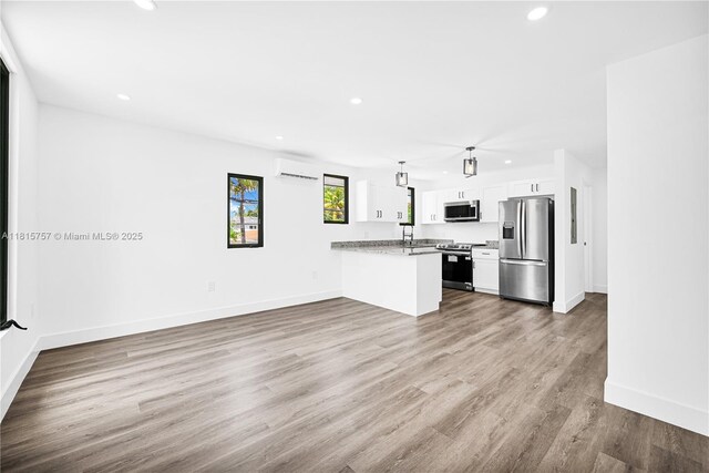 1805 SW 4th St, Miami, FL 33135 - unfurnished living room with a wall unit AC, recessed lighting, and wood finished floors