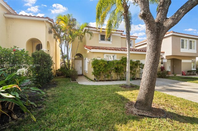 1762 E Trafalgar Cir, Hollywood, FL 33020 - mediterranean / spanish house with a front lawn, stucco siding, concrete driveway, and a tile roof