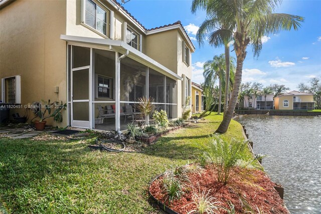 1762 E Trafalgar Cir, Hollywood, FL 33020 - view of property exterior featuring stucco siding, a water view, a yard, and a sunroom