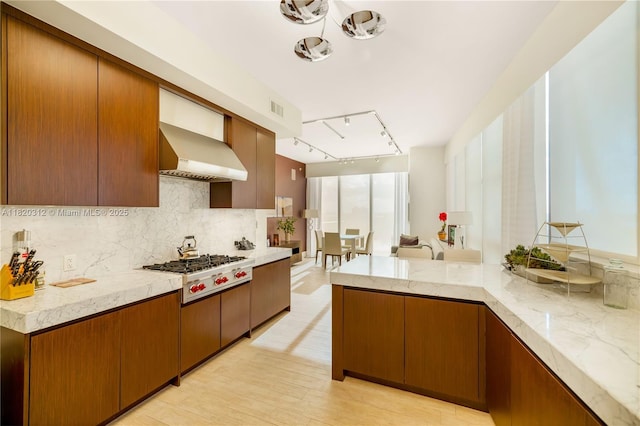 9705 Collins Ave Unit 1101N, Bal Harbour, FL 33154 - kitchen featuring stainless steel gas cooktop, wall chimney exhaust hood, tasteful backsplash, rail lighting, and light wood-style flooring