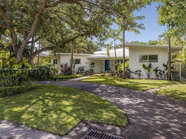 1130 NE 91st Ter, Miami Shores, FL 33138 - view of front of property with stucco siding, a front lawn, and driveway