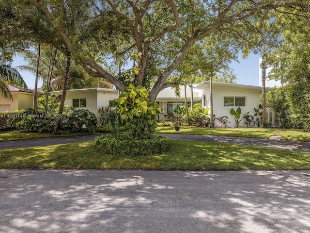 1130 NE 91st Ter, Miami Shores, FL 33138 - view of front of property with stucco siding, a front yard, and asphalt driveway