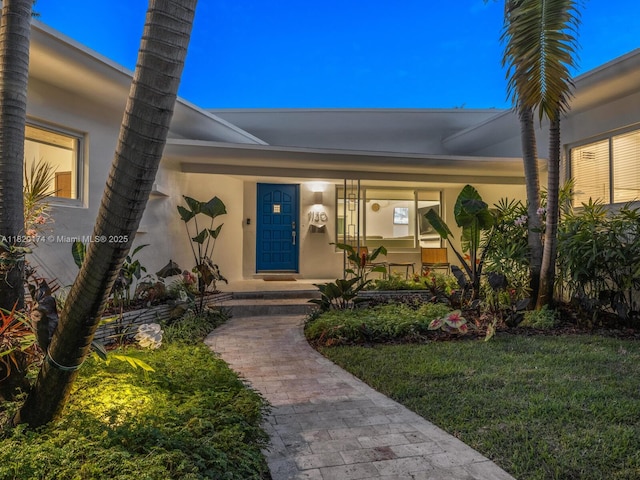 1130 NE 91st Ter, Miami Shores, FL 33138 - entrance to property featuring stucco siding, a porch, and a lawn