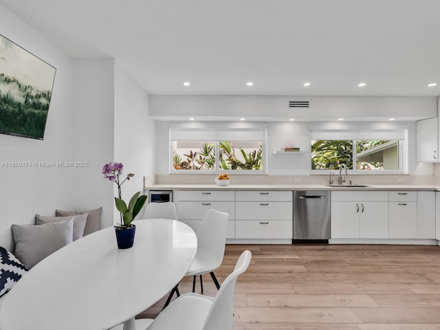 1130 NE 91st Ter, Miami Shores, FL 33138 - kitchen with dishwasher, light wood finished floors, white cabinets, light countertops, and recessed lighting