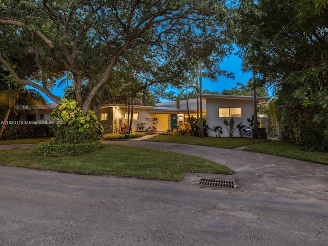 1130 NE 91st Ter, Miami Shores, FL 33138 - view of front of property with a front yard, stucco siding, and curved driveway