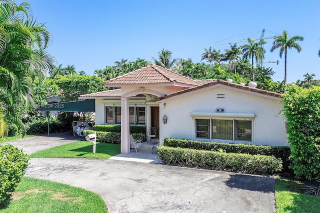 96 Bal Cross Dr, Bal Harbour, FL 33154 - mediterranean / spanish home with a tiled roof, stucco siding, a carport, and driveway