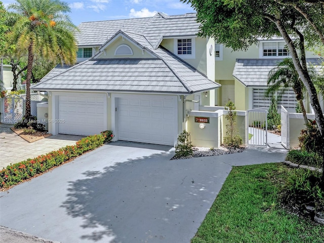 9933 NW 49th Ter, Doral, FL 33178 - view of front of home with stucco siding, a fenced front yard, and an attached garage